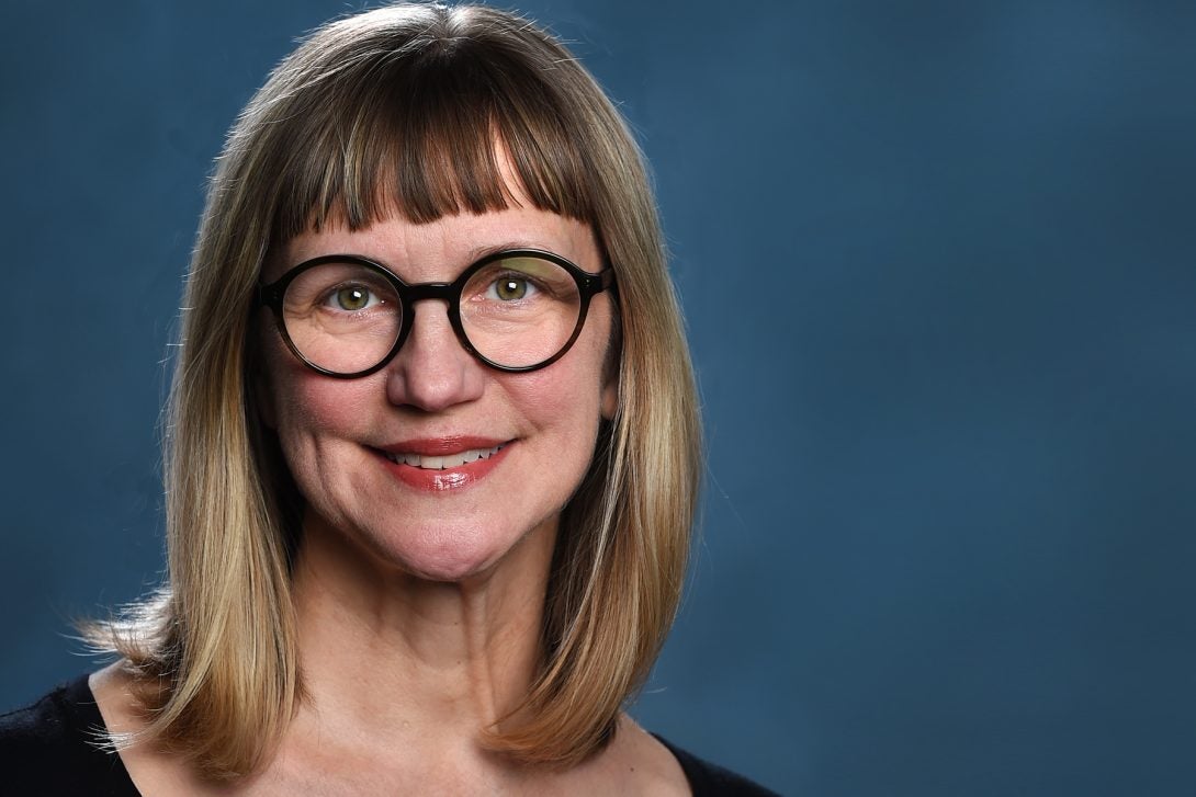 Janet Smith wearing black circle glasses with black background