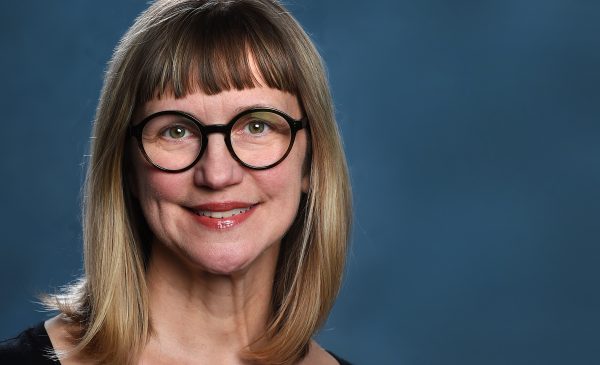 Image of Janet Smith with glasses on and blue background